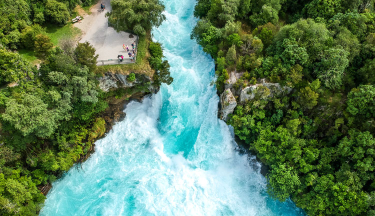 Stunning aerial wide angle drone view of Huka Falls waterfall in Wairakei near Lake Taupo in New Zealand. The waterfall is part of the Waikato River and is a major tourist attraction.