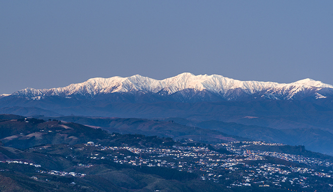 52793TC00 Wellington City and Harbour with snow covered Tararua Ranges above SH1 and SH2 traffic to the Hutt Valley. Wadestown, Thorndon and Kaiwharawhara in foreground. Winter dusk. Wellington, Wellington City District, North Island, NZ