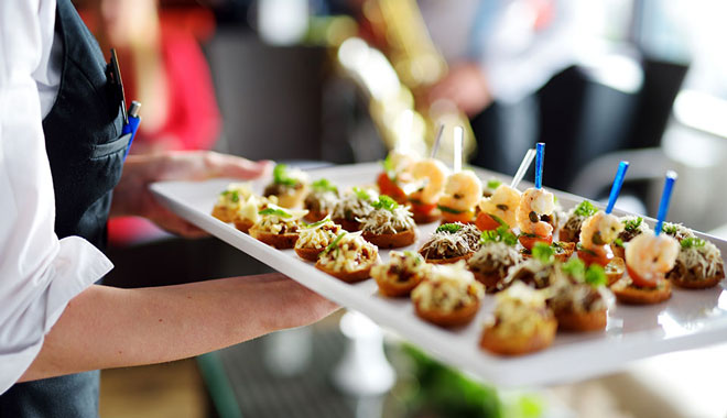 Waiter carrying plates with meat dish